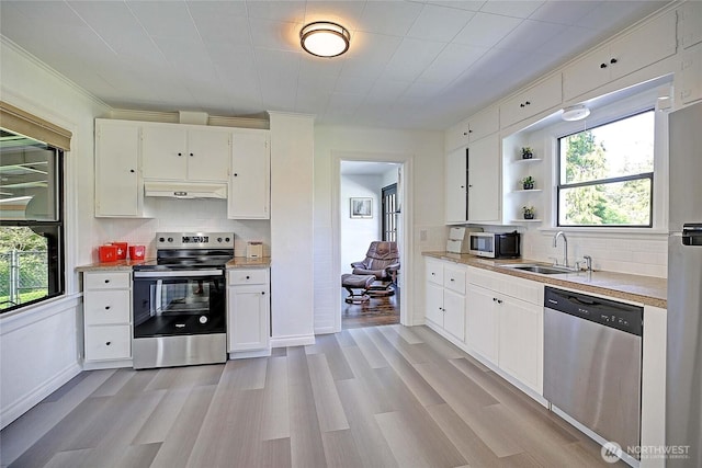 kitchen featuring under cabinet range hood, backsplash, appliances with stainless steel finishes, and a sink