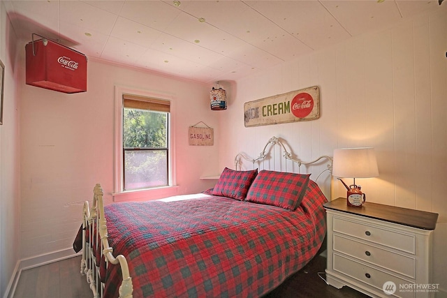 bedroom with baseboards and wood finished floors
