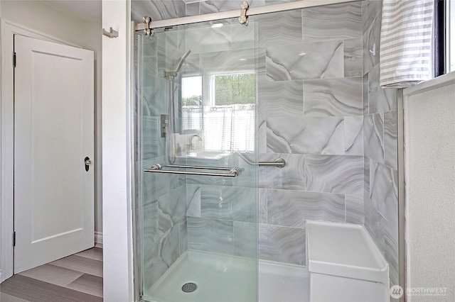 full bath featuring wood finished floors and a shower stall