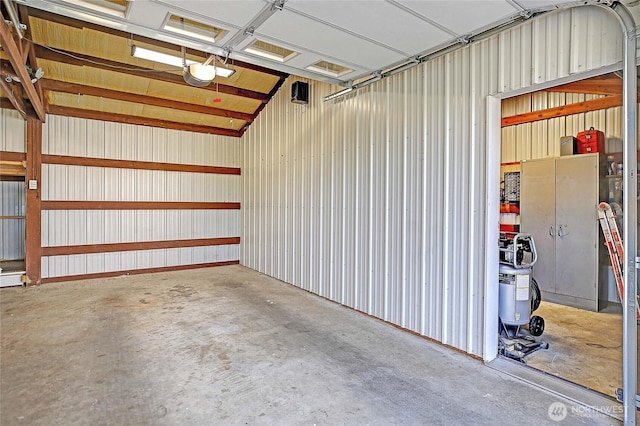 garage with a garage door opener and metal wall