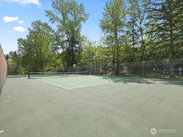 view of tennis court featuring fence