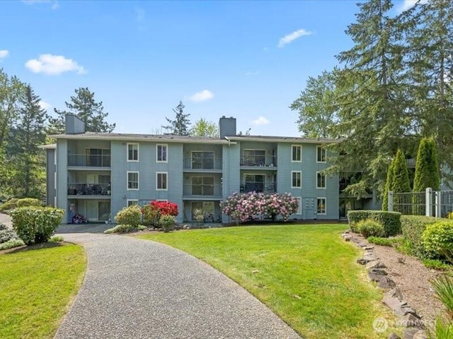 surrounding community featuring a yard, fence, and driveway