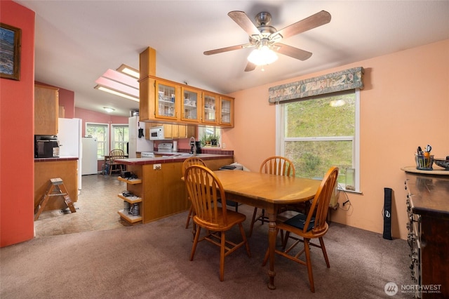 dining space with carpet floors, a ceiling fan, and vaulted ceiling