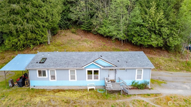 rear view of house with roof with shingles and crawl space