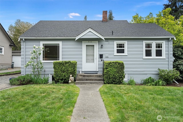 bungalow with a chimney, roof with shingles, and a front lawn