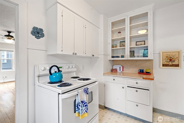kitchen with light countertops, white cabinetry, baseboards, white electric stove, and glass insert cabinets