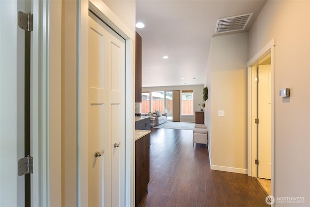 hall featuring recessed lighting, baseboards, visible vents, and dark wood-style floors