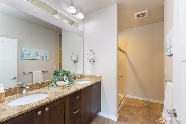 bathroom featuring a sink, a shower stall, and visible vents