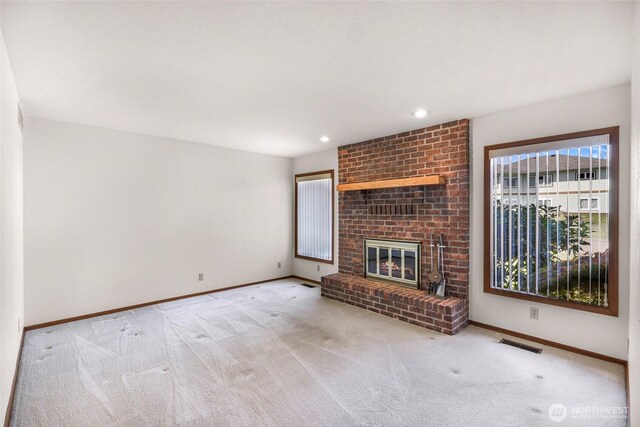 unfurnished living room featuring a fireplace, baseboards, carpet, and visible vents