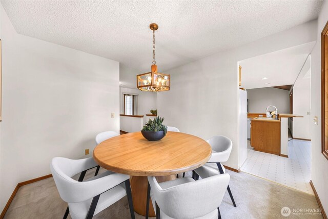 dining area featuring baseboards, a notable chandelier, and light carpet