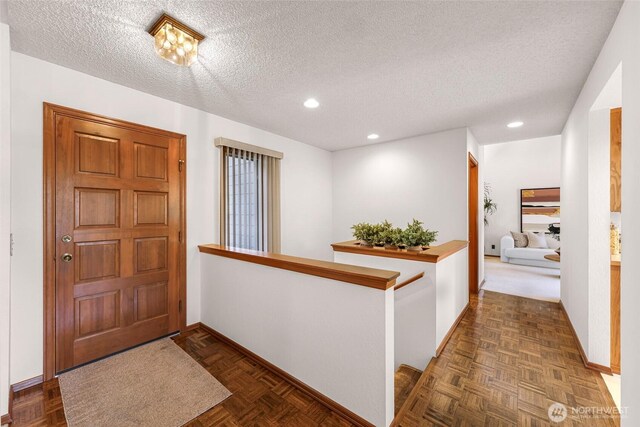 foyer featuring a textured ceiling, baseboards, and recessed lighting