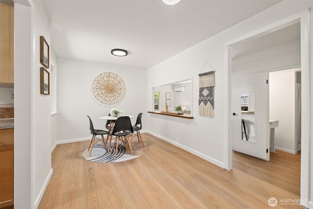 dining room featuring baseboards and light wood finished floors