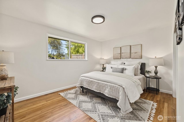 bedroom with baseboards and wood finished floors