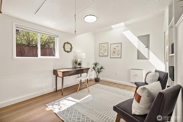 home office featuring baseboards, wood finished floors, and attic access