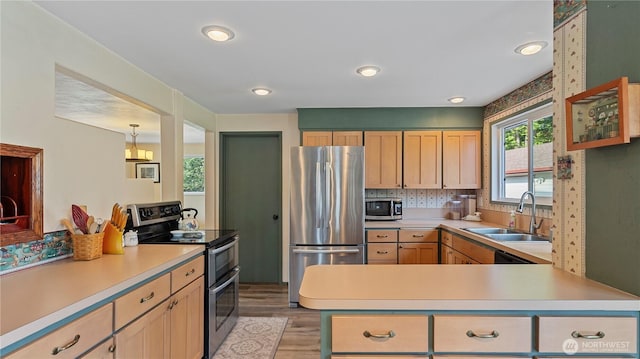 kitchen with a sink, light brown cabinets, appliances with stainless steel finishes, and light countertops
