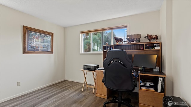 home office with baseboards and wood finished floors