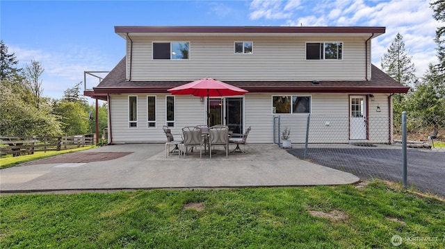 back of property featuring a patio, a yard, a shingled roof, and fence