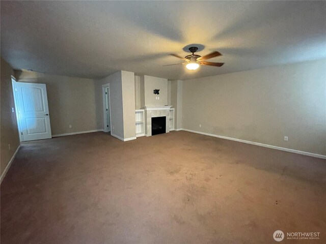 9206 Carys St SE, Yelm, WA 98597 - unfurnished living room with a ceiling fan, carpet floors, and a fireplace