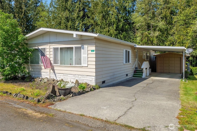 111 Dryke Rd Unit 66, Sequim, WA 98362 - manufactured / mobile home with an outbuilding, aphalt driveway, a carport, and crawl space