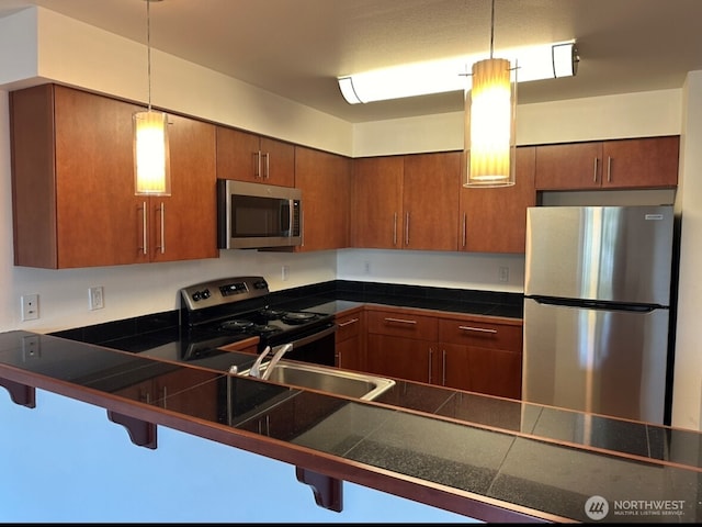 1400 N 80th St, Seattle, WA 98103 - kitchen with brown cabinetry, pendant lighting, a kitchen breakfast bar, a sink, and appliances with stainless steel finishes