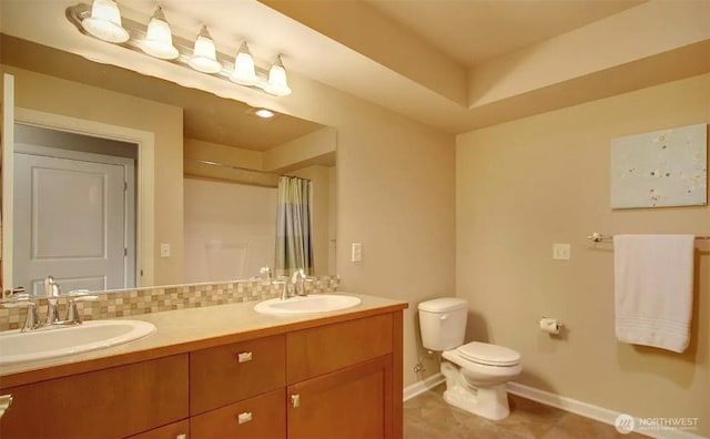 1400 N 80th St, Seattle, WA 98103 - bathroom with baseboards, a sink, double vanity, and toilet