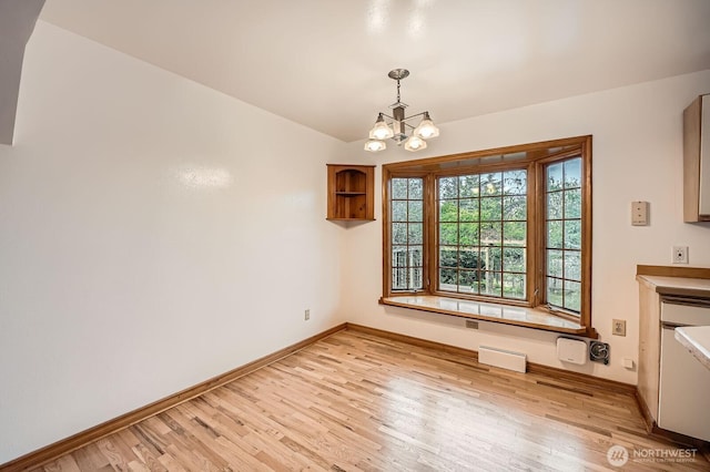 unfurnished dining area featuring light wood-type flooring, baseboards, visible vents, and an inviting chandelier