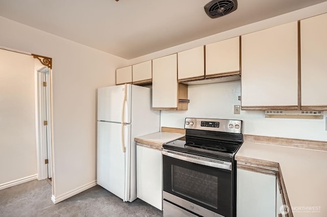 kitchen with light colored carpet, electric stove, freestanding refrigerator, and light countertops
