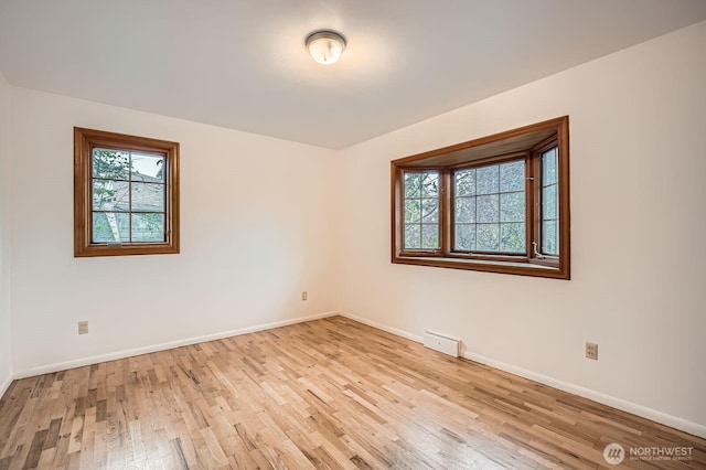 empty room with baseboards and light wood finished floors