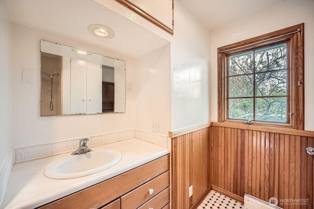 bathroom featuring vanity, wood walls, a baseboard heating unit, and a wainscoted wall