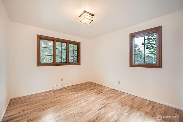 unfurnished room featuring baseboards and light wood-type flooring