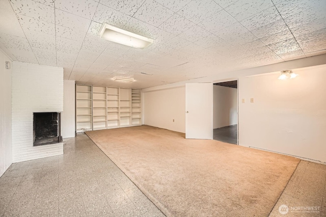 finished basement with built in features and a fireplace