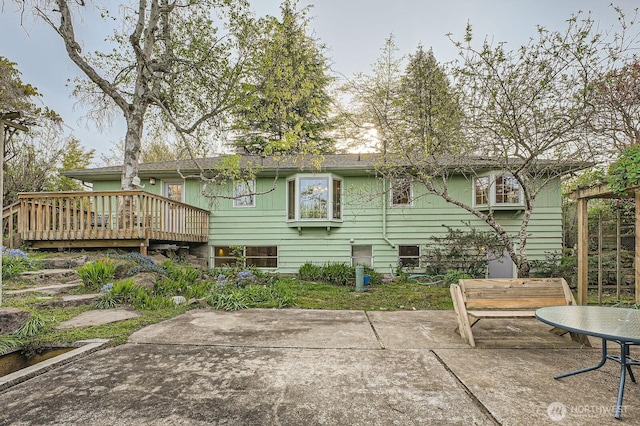 back of property featuring a patio and a deck