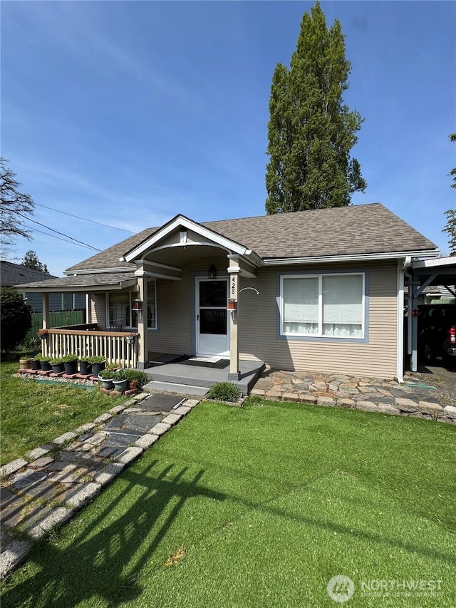 view of front of house with a front lawn, covered porch, and roof with shingles