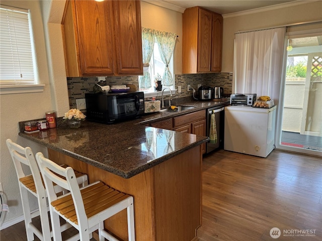 kitchen featuring tasteful backsplash, stainless steel dishwasher, a sink, black microwave, and ornamental molding
