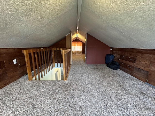 bonus room with wood walls, carpet, vaulted ceiling, and a textured ceiling