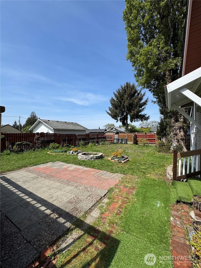 view of yard with a fire pit, a fenced backyard, and a patio area