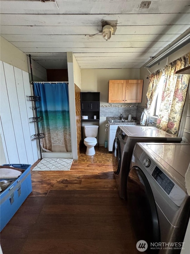 washroom with a sink, hardwood / wood-style floors, independent washer and dryer, and laundry area