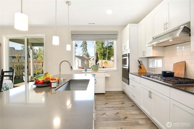 22125 Jameson Ave NW, Poulsbo, WA 98370 - kitchen with under cabinet range hood, stainless steel gas cooktop, a sink, light wood-type flooring, and white cabinets