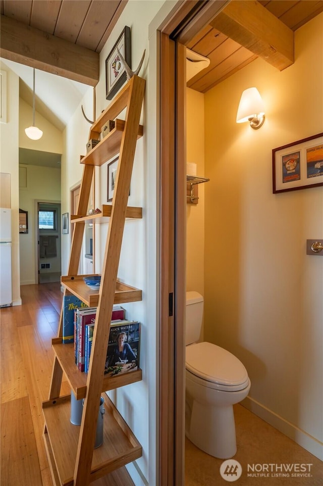 bathroom with lofted ceiling with beams, wood finished floors, wood ceiling, toilet, and baseboards