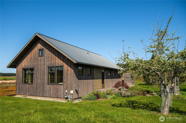 rear view of property with a yard and metal roof