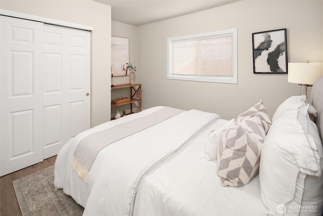 bedroom with wood finished floors and a closet