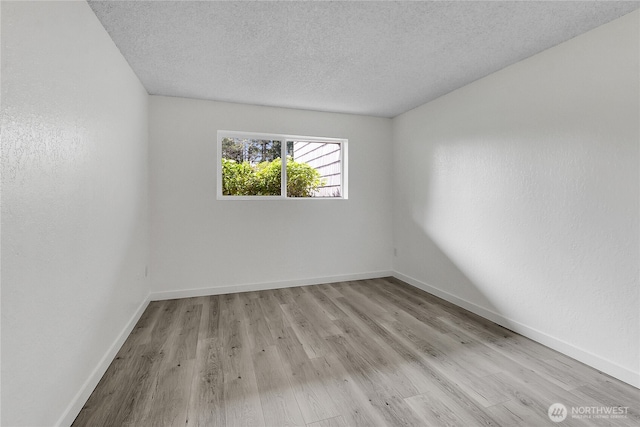 21615 80th Ave W Unit 101, Edmonds, WA 98026 - spare room featuring baseboards, a textured ceiling, and light wood-style flooring
