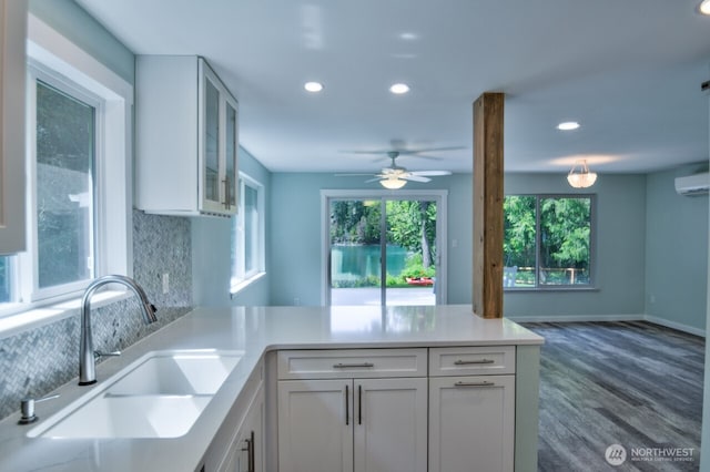 41 SE Wildcat Cove Rd, Shelton, WA 98584 - kitchen with a sink, a peninsula, recessed lighting, white cabinetry, and a wall mounted air conditioner