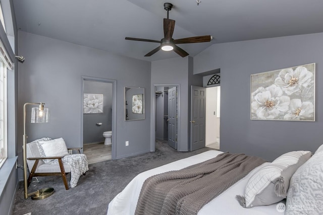 bedroom featuring lofted ceiling, ensuite bathroom, baseboards, a spacious closet, and carpet