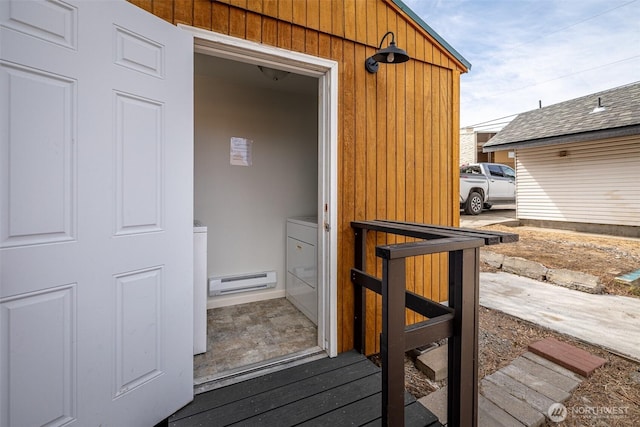view of exterior entry with washing machine and dryer and a baseboard radiator
