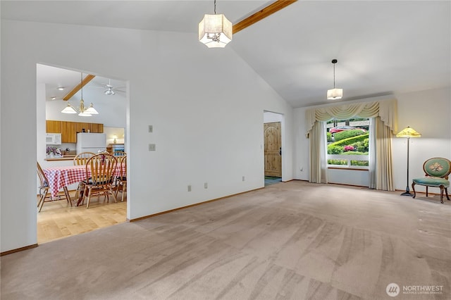 unfurnished living room featuring light colored carpet, high vaulted ceiling, beamed ceiling, baseboards, and a chandelier
