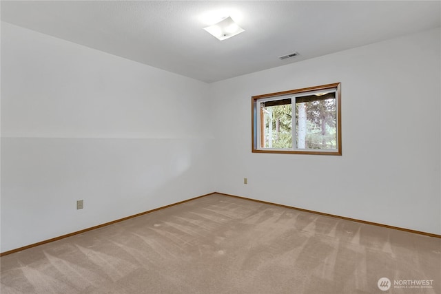 carpeted spare room featuring baseboards