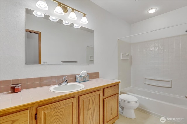 bathroom featuring toilet, vanity, and shower / washtub combination