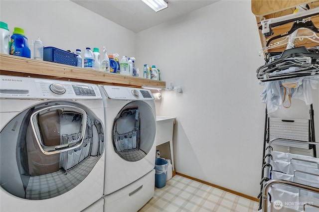 laundry area with washer and dryer, light floors, and baseboards