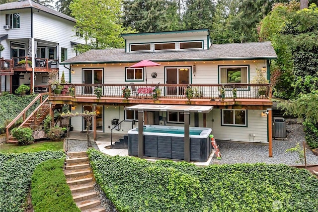 back of house with a hot tub, stairs, a patio area, central AC, and a deck